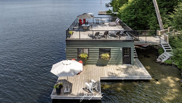 Een vakantiehuis aan het meer met terras, buitenmeubels en een kleine tuin.
