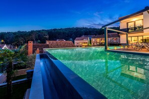 A swimming pool with a view of a modern house and surrounding buildings. - Villa Emotha-Five Bedroom villa with Pool (Korcula)