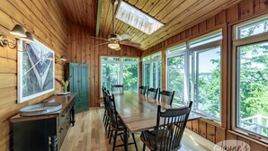 A wooden-paneled room with a large dining table, chairs, and a ceiling fan. - Island Property on Lake Muskoka! 4brdm, 3 bath! Best Internet! SUP, Kayak (Bracebridge)