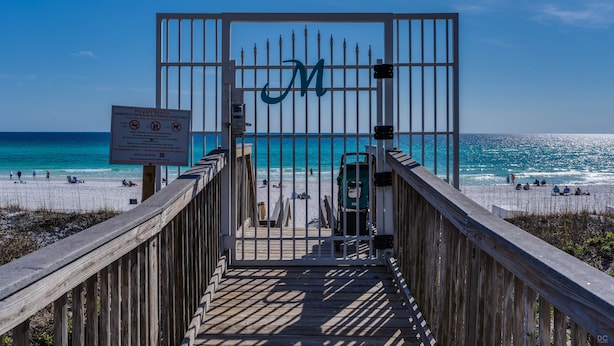 A wooden boardwalk leading to a private beach with a gate marked with a large 'M'. - 🏖️ Maravilla ~ private beach ~ includes beach setup of 4 chairs, 2 umbrellas 🏖️ (Miramar Beach)