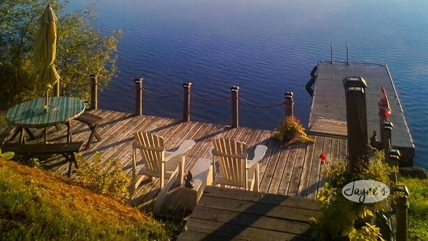 A wooden dock with chairs and an umbrella overlooking a calm lake with mist. - 4 bedroom, 4 bath, Quiet Butterfly Lake! Port Carling! Cozy & Spacious! (Port Carling)