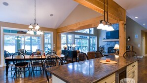 A spacious kitchen with a large island, wooden beams, and a stone fireplace. - 4 bedroom, 4 bath, Quiet Butterfly Lake! Port Carling! Cozy & Spacious! (Port Carling)