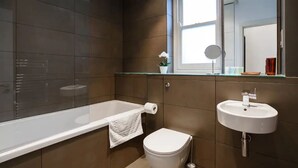 A modern bathroom with a glass-enclosed shower, a white toilet, and a sink with a mirror above it. - 15% Off 4 Night Stays | Boutique 1 Bed Apartment (Cardiff)