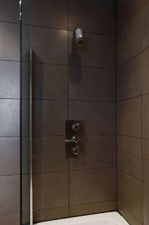 Een bad/douchecombinatie, een haardroger, handdoeken, zeep