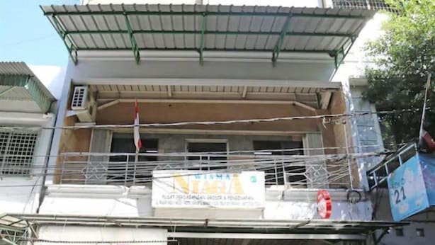 A building with a covered entrance and a signboard. - OYO 3865 Wisma Niaga (Jakarta)