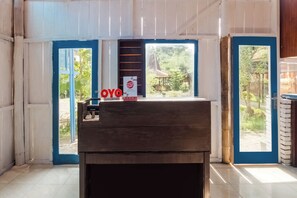 Una mesa de recepción con un cartel que dice 'OYO' y un teléfono Sharp.
