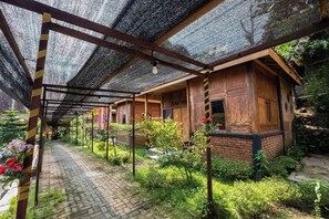 Una estructura de madera cubierta con un sendero de ladrillo que la lleva a ella.