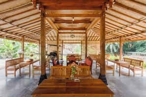 A covered wooden pavilion with benches and tables, surrounded by lush greenery. - OYO 3562 Pondok Inspirasi Minggir (Minggir)