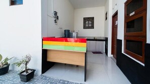 Un petit bureau aux couleurs vives, doté d’un distributeur d’eau et agrémenté d’une plante en pot.