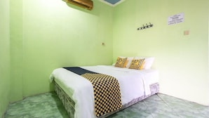 A room with a bed, green walls, a blue ceiling, and an air conditioning unit. - Spot ON 3961 Fico's Residence Syariah (Bekasi)