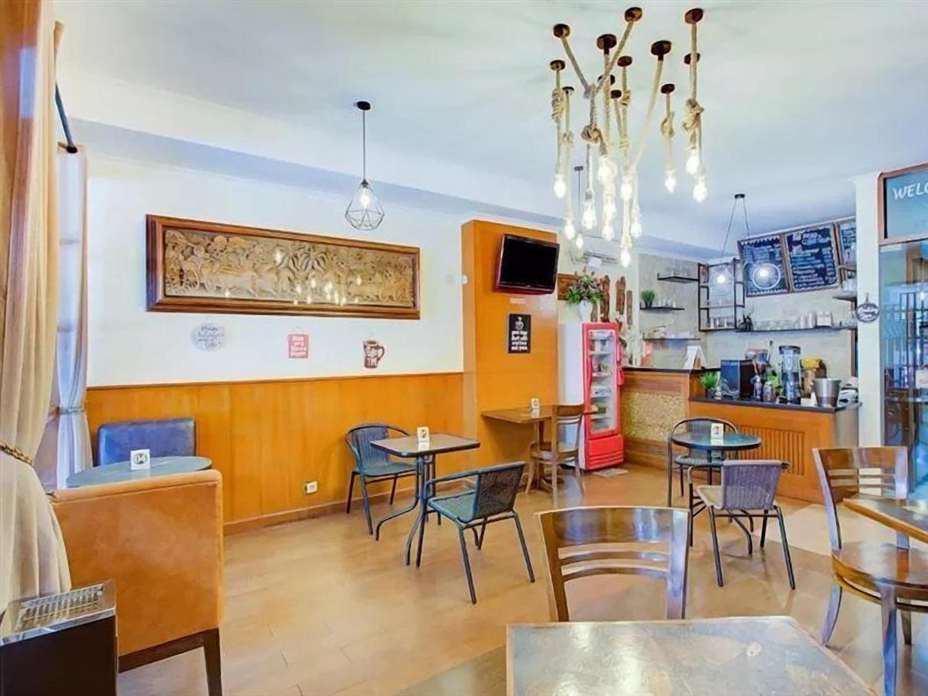 Un restaurante con paredes de madera, un gran mural decorativo y diversas opciones de asientos, incluyendo mesas y sillas.