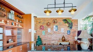 Une cuisine avec des meubles en bois, un mur de fond en briques et un îlot central.