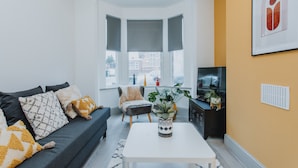 A modern living room with a sofa, armchairs, a coffee table, and a TV. - Entire House with Parking in Rugby (Rugby)