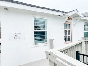 Ein weißes Gebäude mit Balkon und einer Tür.