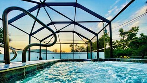 Un jacuzzi con estructura metálica y vista al cielo y a los árboles.