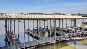 Un muelle con techo de metal y pasarelas de madera.