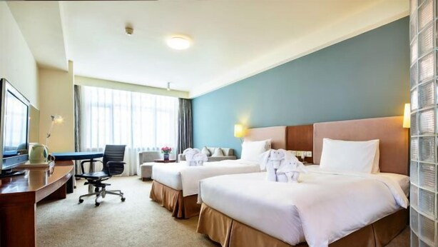 A hotel room with two beds, a desk, a chair, and a television. - Tianjin Binhai Saint Light Hotel (Tianjin)