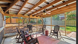 A covered patio with a ceiling fan, wooden beams, and a view of a backyard. - Beachy Isle of Palms Private Bungalow! Walk to Beach! Pet Friendly. (Isle of Palms)