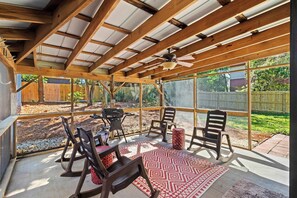 A covered patio with a ceiling fan, wooden beams, and a view of a backyard. - Beachy Isle of Palms Private Bungalow! Walk to Beach! Pet Friendly. (Isle of Palms)