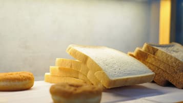 Slices of white bread and a round pastry on a white surface.