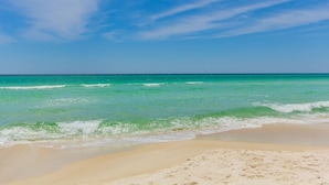 A beach with clear turquoise water and a sandy shore.