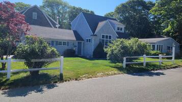 A two-story house with a sloped roof, a front porch, and a small attached garage.