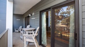 A covered outdoor area with a table and chairs, a sliding glass door, and a number '245' sign.
