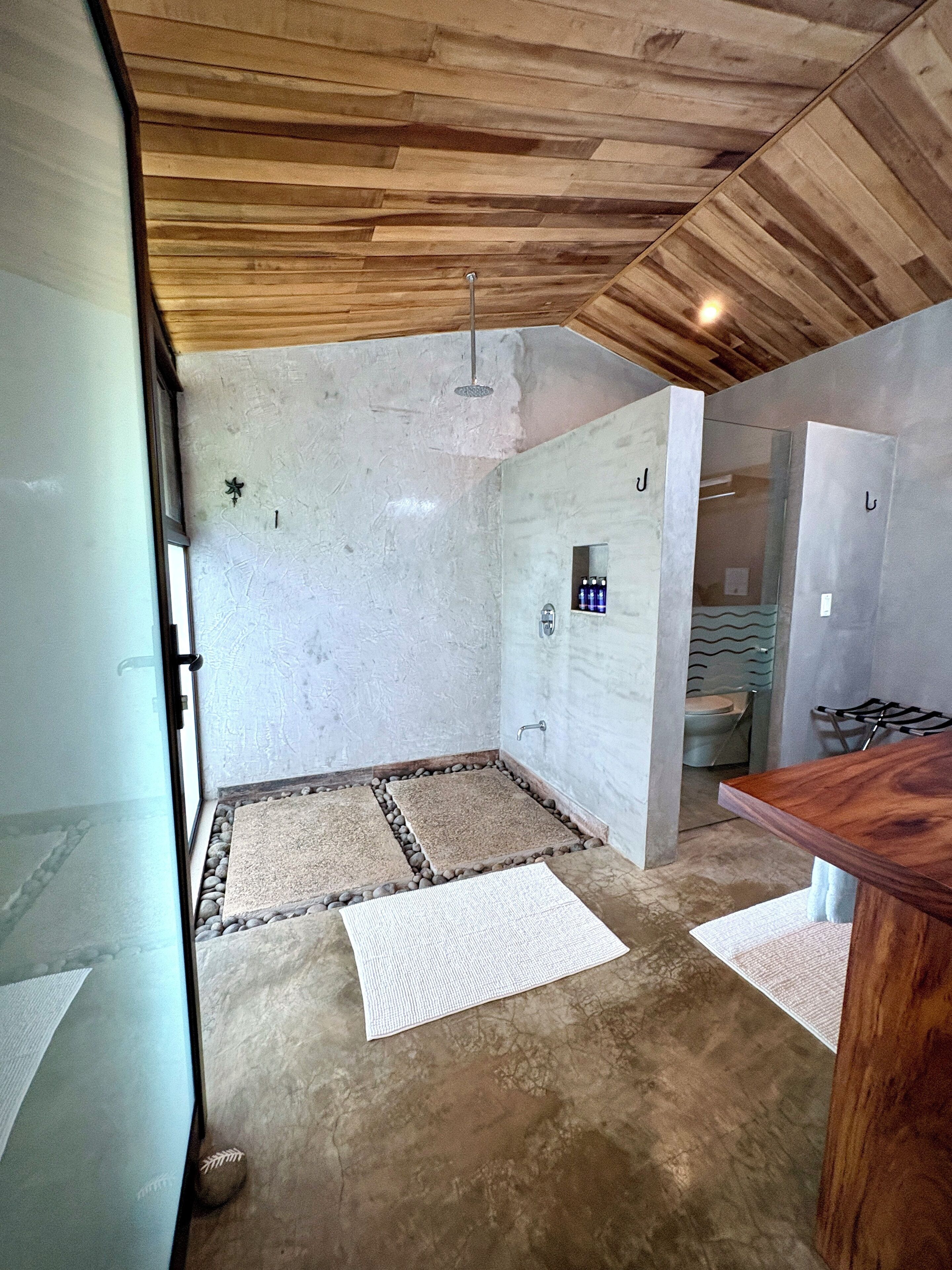 A bathroom with a shower, a toilet, and a sink.