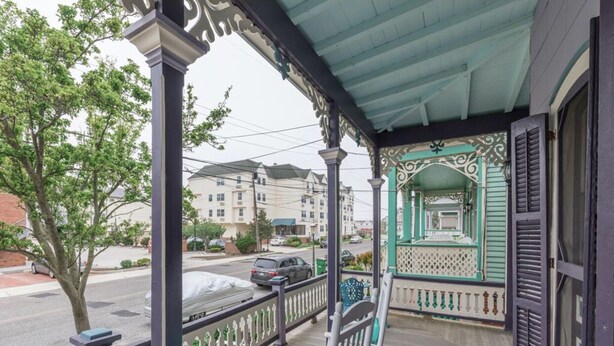 Un portico con ringhiera, una panchina e un'area coperta con un arco decorativo.
