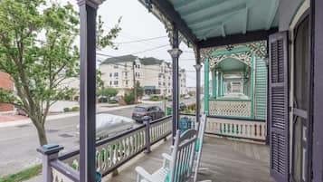 Une véranda dotée d’une balustrade, d’un banc et d’un espace abrité agrémenté d’une arche décorative.