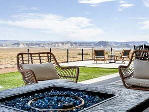 An outdoor seating area with wicker furniture and a fire pit. - Surf Inn Lake Powell • Sleeps 15 • Hot Tub & Views (page)