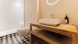 A bathroom with a white sink, wooden vanity, and a mirror. - Magnificent Bordeaux studio in beautiful stone in the heart of the city (Bordeaux)