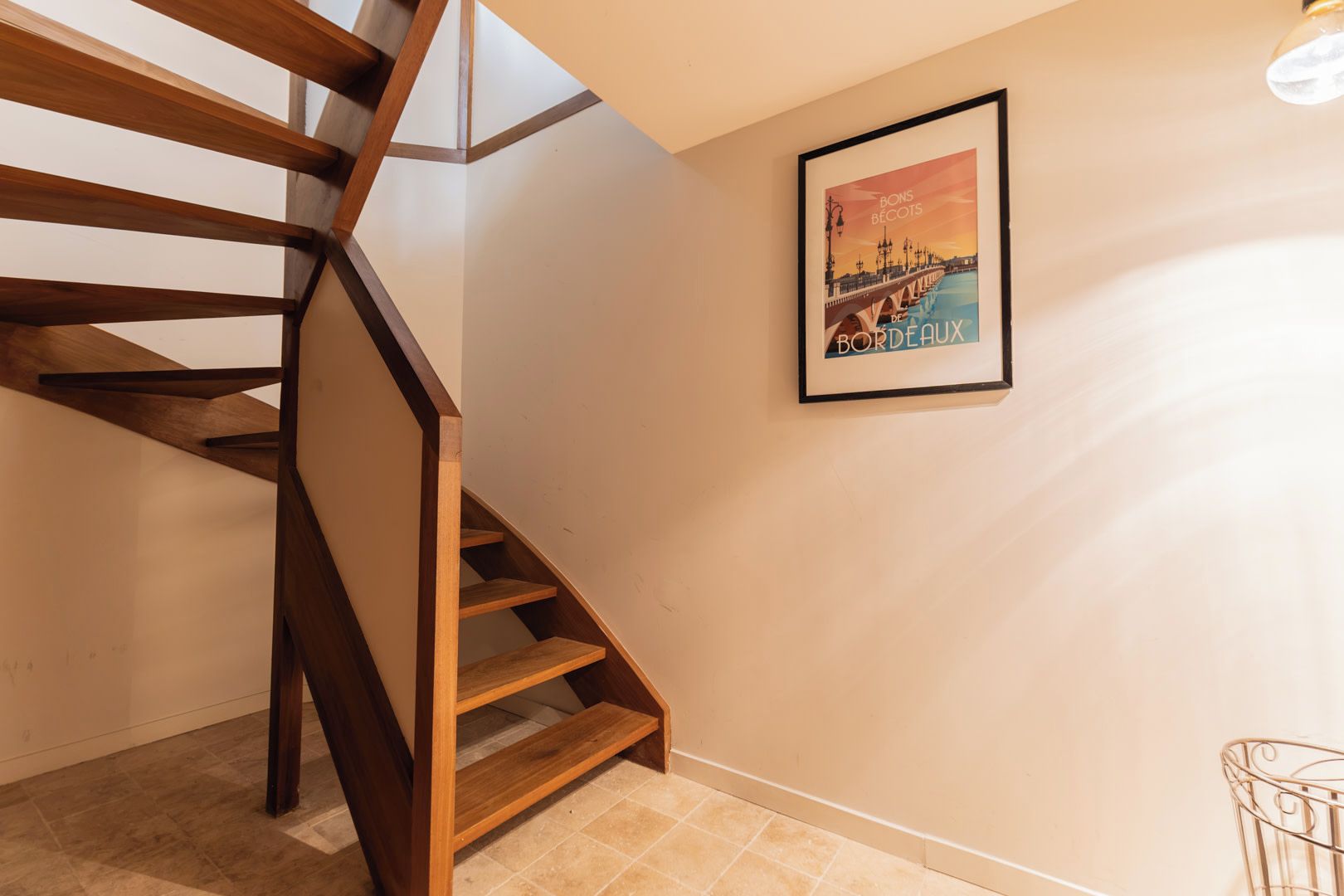 A wooden staircase with a framed poster on the wall.