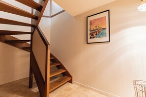 Una escalera de madera con un cartel enmarcado en la pared.