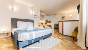 A modern hotel room with a bed, bedside table, and a desk area. - Magnificent Bordeaux studio in beautiful stone in the heart of the city (Bordeaux)