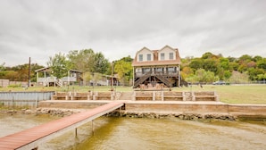 A house with a dock extending into a pond. - Lake Granbury Fishing Escape w/ Dock & Kayaks! (Granbury)