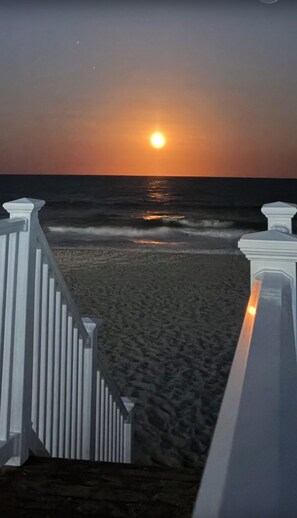 A sunset over the ocean with a wooden deck leading to the beach. - OCEANFRONT 2 BD, 2.5 BTH in SURFSIDE! (Surfside Beach)