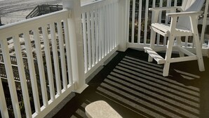 A covered porch with white railings and two Adirondack chairs. - OCEANFRONT 2 BD, 2.5 BTH in SURFSIDE! (Surfside Beach)