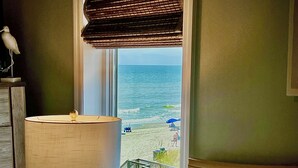 A room with a view of the beach, a lamp, and a bench by the window. - OCEANFRONT 2 BD, 2.5 BTH in SURFSIDE! (Surfside Beach)