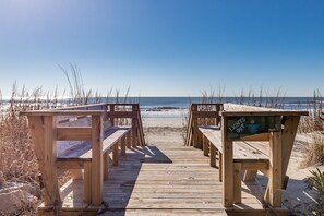 Een houten looppad dat naar het strand leidt, met een bord waarop staat: "Lights Out voor Schildpadden."