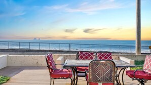 Una terraza con asientos al aire libre con vista al océano.