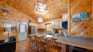 A wooden cabin interior with a kitchen, dining area, and a living room. - Close ‘n Secluded❤️Mountain Views*PRIVATE RESORT*Hot Tub*Cabin😊A+++ (Sevierville)
