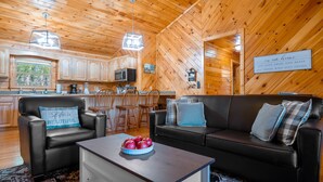 A cozy cabin interior with a wooden interior, a dining area, and a living room with a sofa and chairs. - Close ‘n Secluded❤️Mountain Views*PRIVATE RESORT*Hot Tub*Cabin😊A+++ (Sevierville)