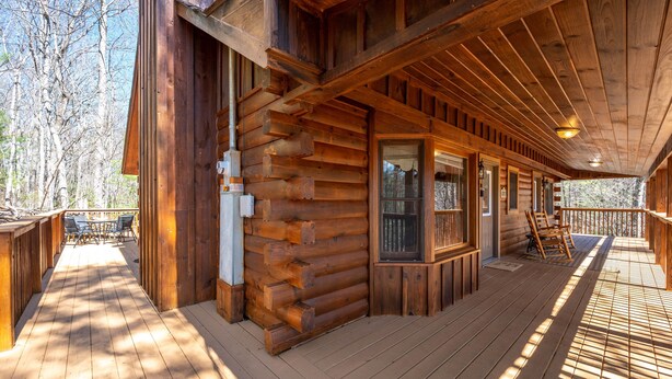 A log cabin with a wooden deck, a covered porch, and a view of the surrounding forest. - Close ‘n Secluded❤️Mountain Views*PRIVATE RESORT*Hot Tub*Cabin😊A+++ (Sevierville)