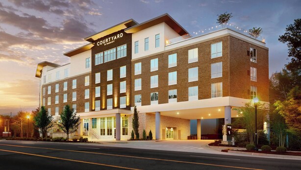 A Courtyard hotel with a modern design, featuring a flat roof, large windows, and a well-lit entrance. - Courtyard® by Marriott® Atlanta Dunwoody (Atlanta)