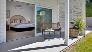 Une chambre à coucher avec un lit, une chaise et une plante en pot sur un balcon.