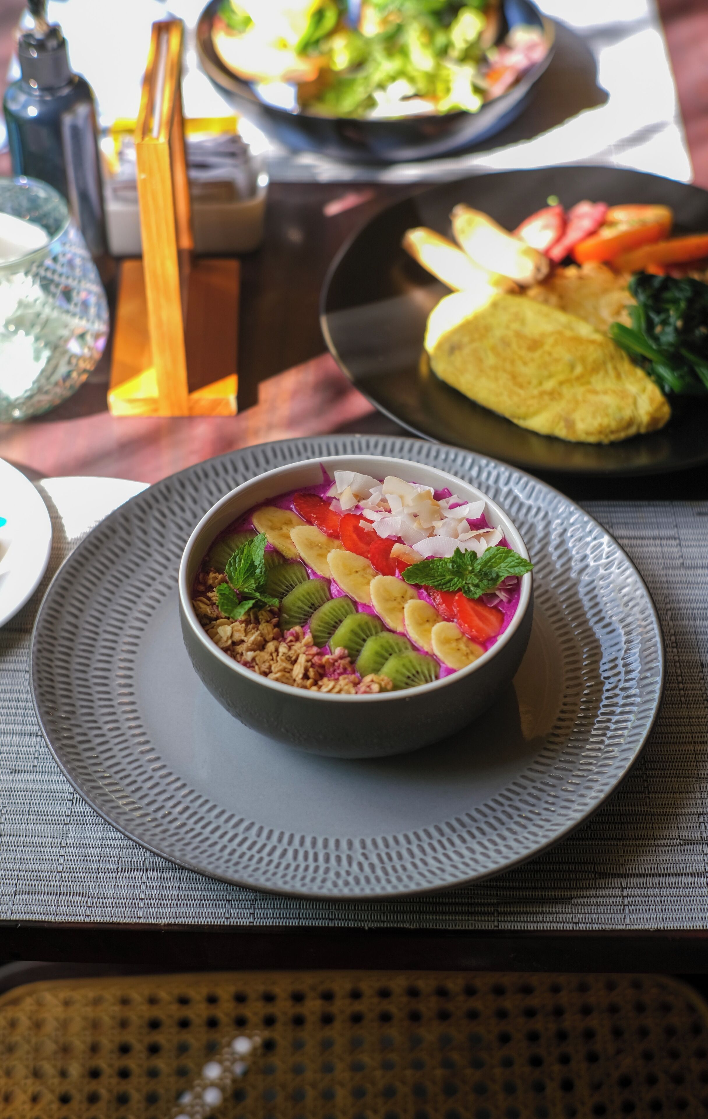 A bowl of colorful fruit salad on a textured plate.