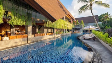 Una piscina al aire libre, sillones reclinables de piscina