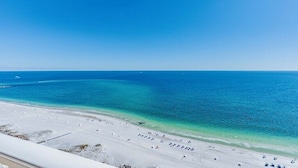 Ein Strand mit weißem Sand und klarem, blauem Wasser.