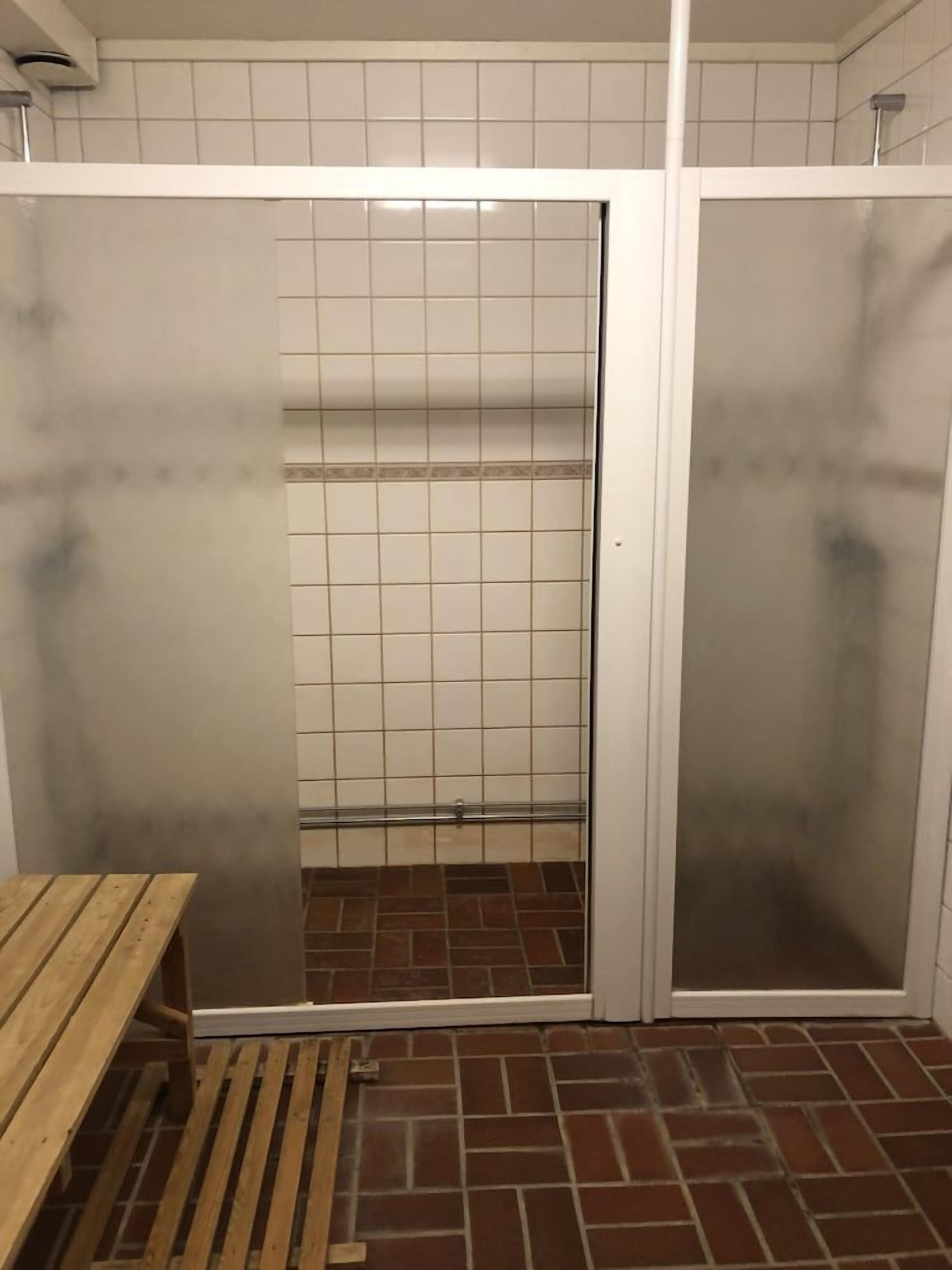 A tiled shower area with a bench and a tiled floor.